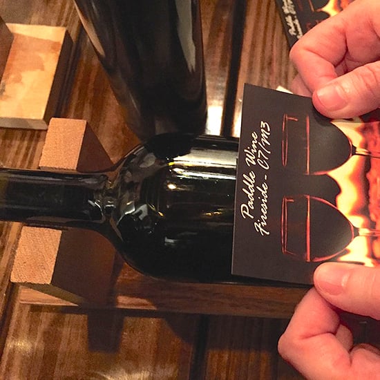 Lining the label up to apply to the wine bottle straight.