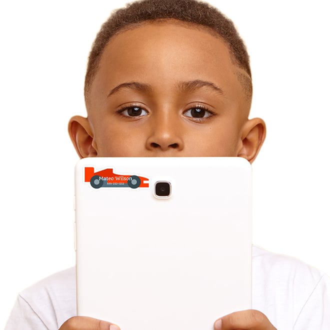 Race car shaped name labels. School age child holding a tablet with his name label on it. Keep track of all of your kid's things with shaped name stickers.