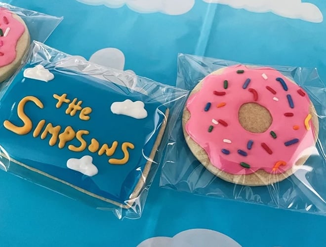 Simpsons theme custom cookies found on Etsy. One displays the Simpsons opening picture and one is a pink donut cookie.