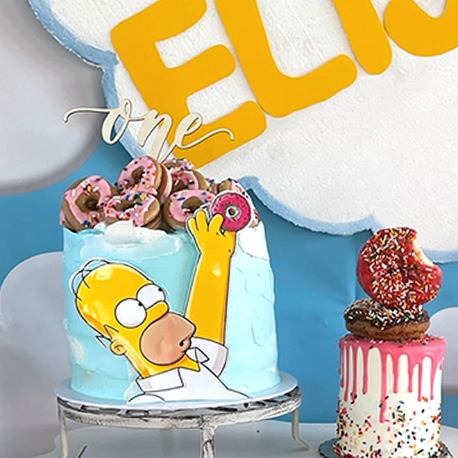 Homer is reaching for a donut on this clever cake topper.